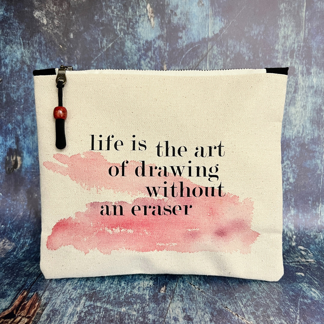 square canvas zipper pull bag with the words, life is the art of drawing without an eraser