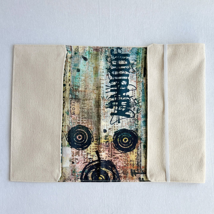 the inside lining of a reusable book cover, with duck canvas on the outside, and a colorful fabric on the inside. 