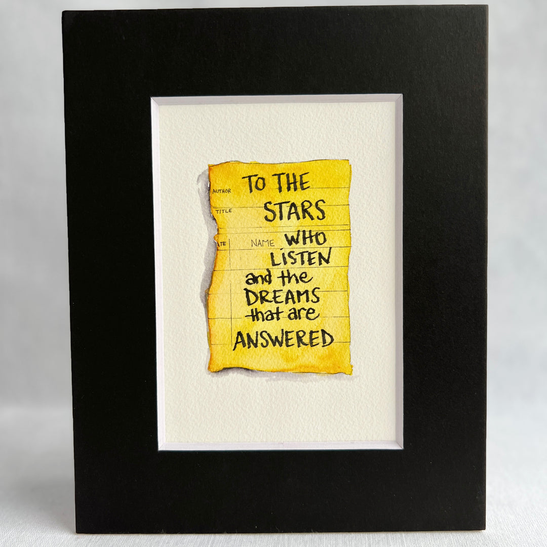 The image of an aged, sepia-toned due-date card is rendered in rich golden yellow watercolor, with inked lines for author and title. The words, "To the stars who listen and the dreams that answered," are printed in black ink. The print is matted with a black mat.
