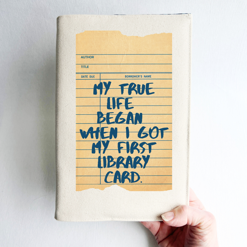 Canvas, reusable book covers in linen, with the words, 'My true life began when I got my first library card' printed on a vintage-style library check out card design.