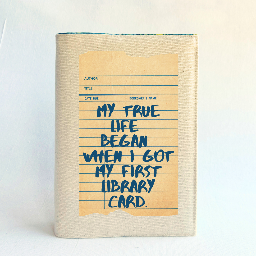 Canvas, reusable book covers in linen, with the words, 'My true life began when I got my first library card' printed on a vintage-style library check out card design.