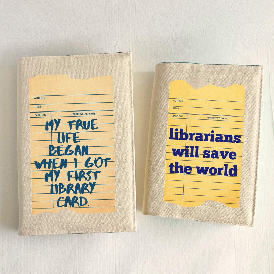 Canvas, reusable book covers in linen, both printed on vintage-style library check out card designs. One has the words,  'librarians will save the world,' and the other other says, 'My true life began when I got my first library card.'