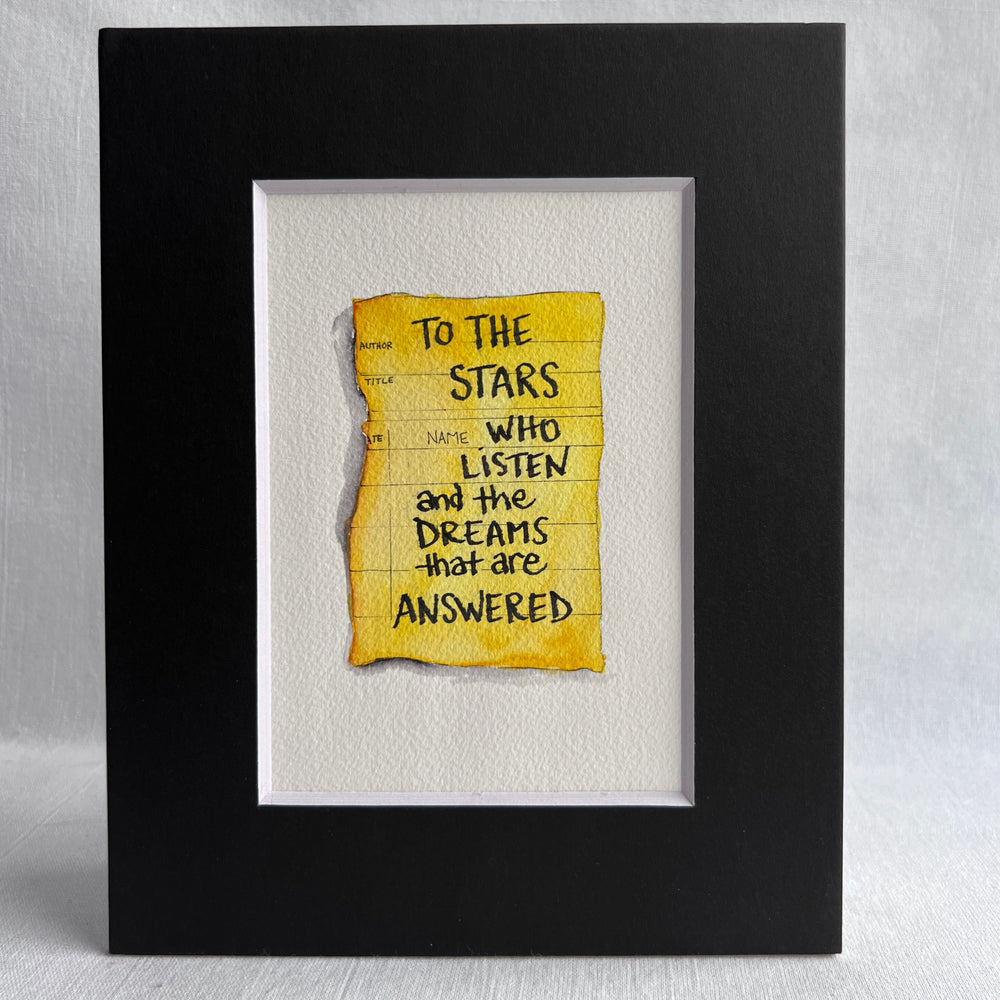 The image of an aged, sepia-toned due-date card is rendered in rich golden yellow watercolor, with inked lines for author and title. The words, "To the stars who listen and the dreams that answered," are printed in black ink. The print is matted with a black mat.
