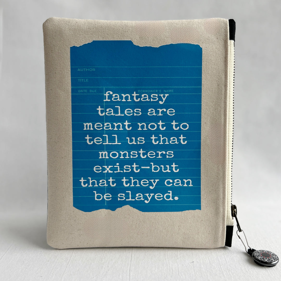 padded canvas zip bag with a blue  library card and the words, Fantasy Tales are not meant to tell us that monsters exist, but that they can be slayed, plus a colorful zipper pull and lining
