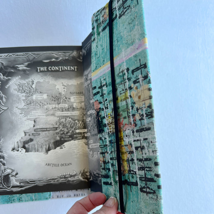 the inside back cover of a book covered in a vibrant blue green fabric reusable book cover with the words, 'live out loud' printed on the top.