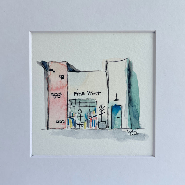 A framed watercolor sketch of a storefront scene with the words 'Fine Print' visible, shown against a light gray background.