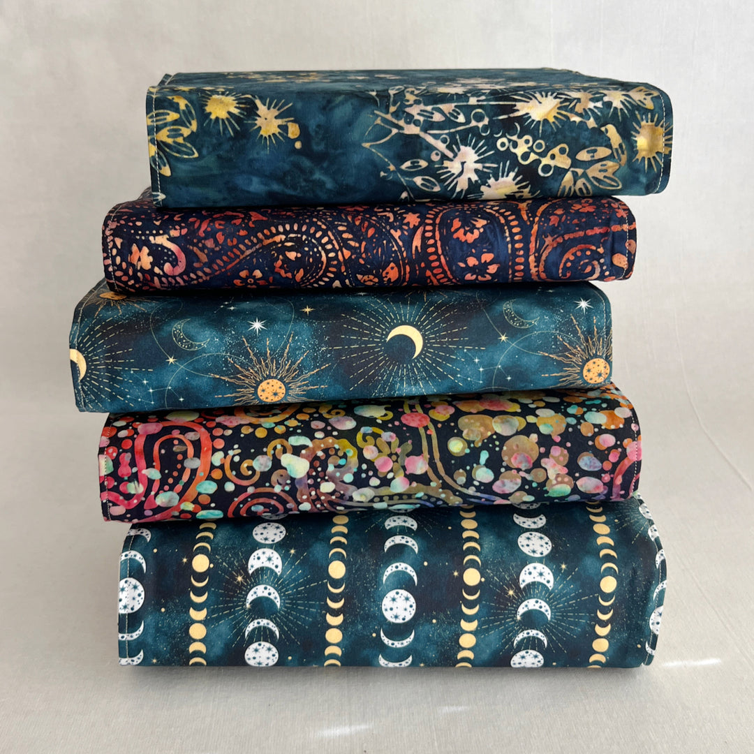 a stack of book covers made in rich, luscious fall colors of deep orange, blue-greys and paisley multicolors