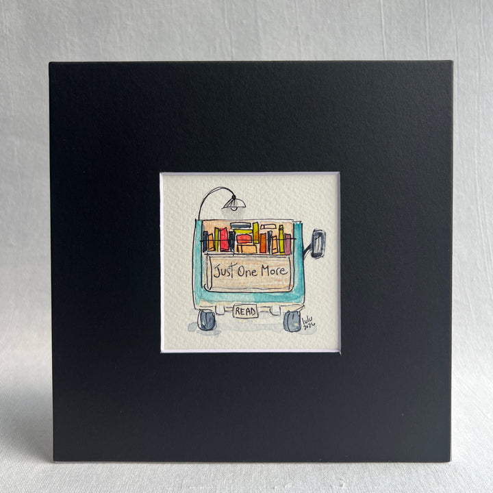 A square original watercolor art print depicting the back end of a blue pickup truck loaded with colorful books and a wonky reading light, with the words, "Just One More' and a license plate with the word 'Read'