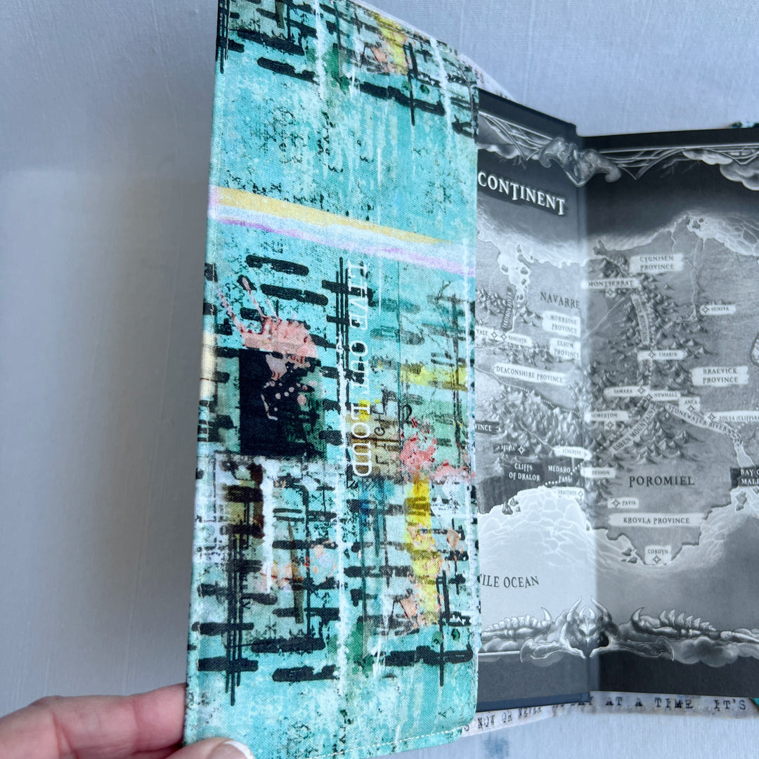 the inside front cover of a book covered in a vibrant blue green fabric reusable book cover with the words, 'live out loud' printed on the top.