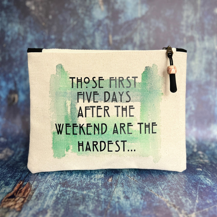 rectangular canvas zip pouch in linen color, with a zipper pull.  Green watercolor paint is the background for the words, those first five days after the weekend are the hardest, in black lettering.