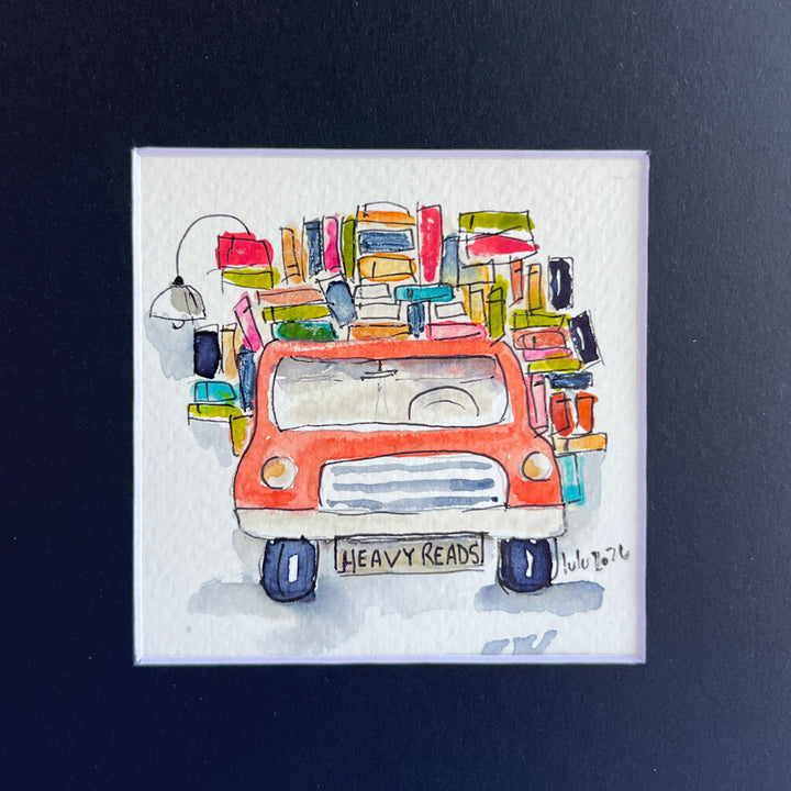 A square original watercolor art print depicting a red pickup truck loaded with colorful books and a wonky reading light, with the license plate reading 'HEAVY READS' 