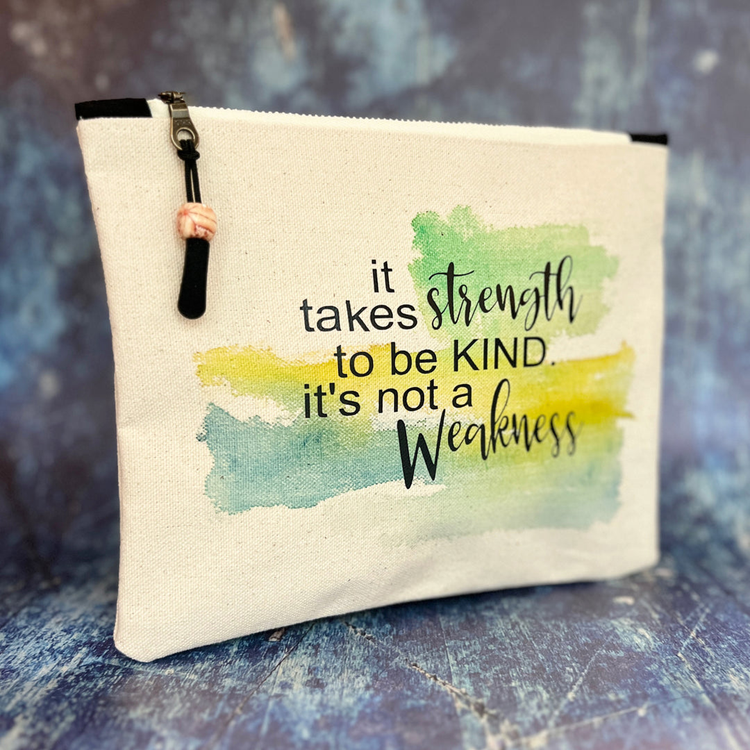 square canvas zipper pull bag with the words, it takes strength to be kind, it's not a weakness.