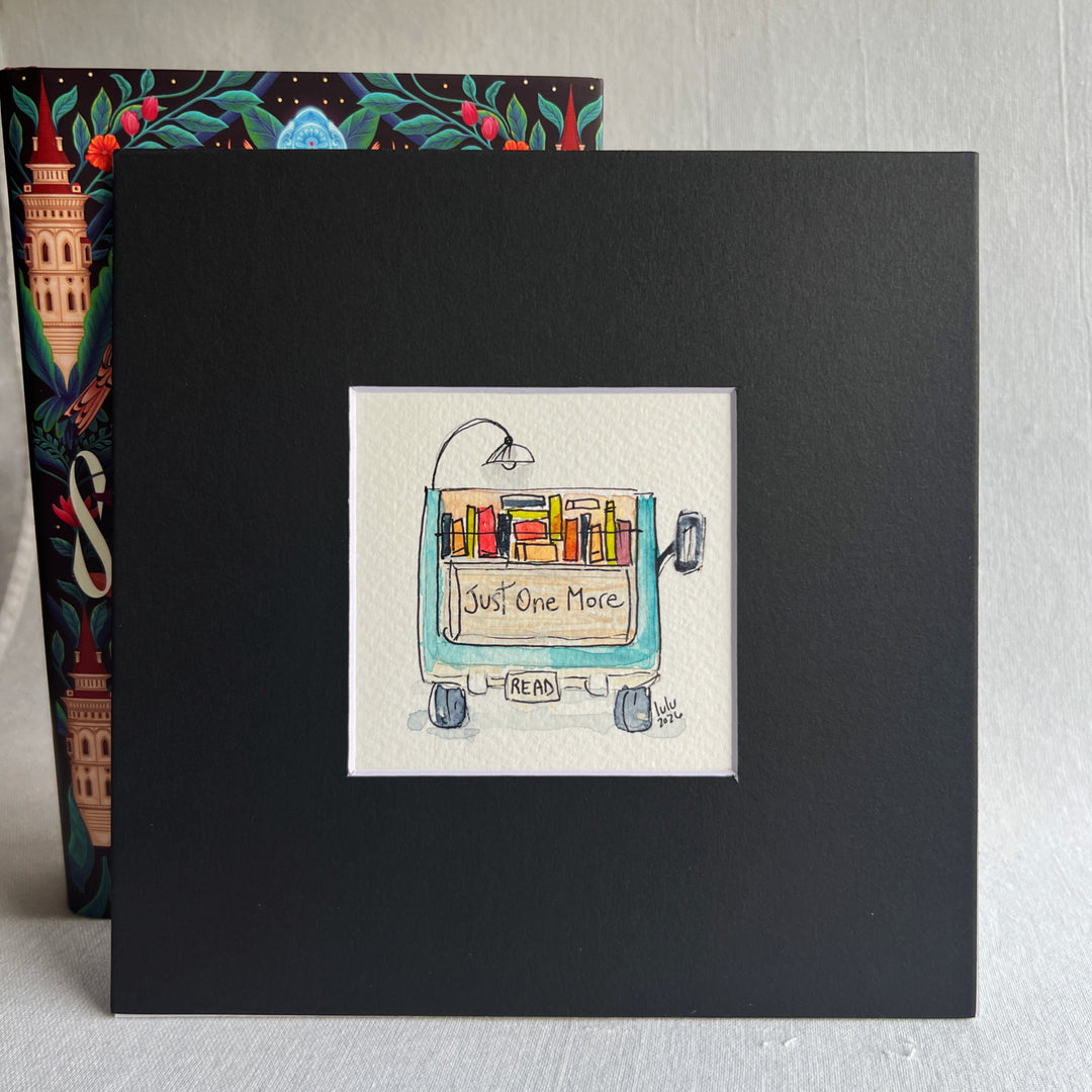 A square original watercolor art print depicting the back end of a blue pickup truck loaded with colorful books and a wonky reading light, with the words, "Just One More' and a license plate with the word 'Read'