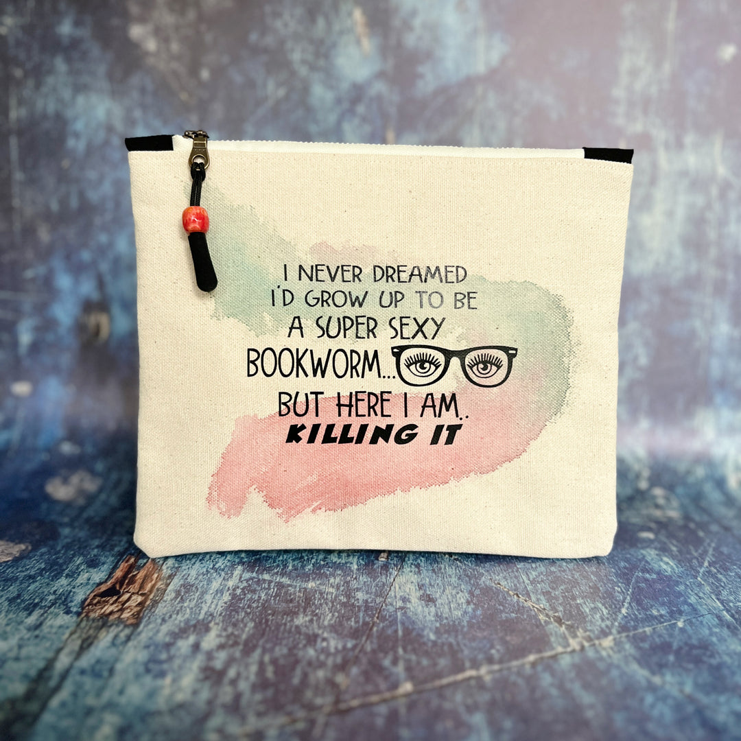 9x7 inch canvas bag with a zipper pull, watercolor paint swashes and the words, "I never dreamed I'd grow up to be a super sexy bookworm..but here I am..killing it."