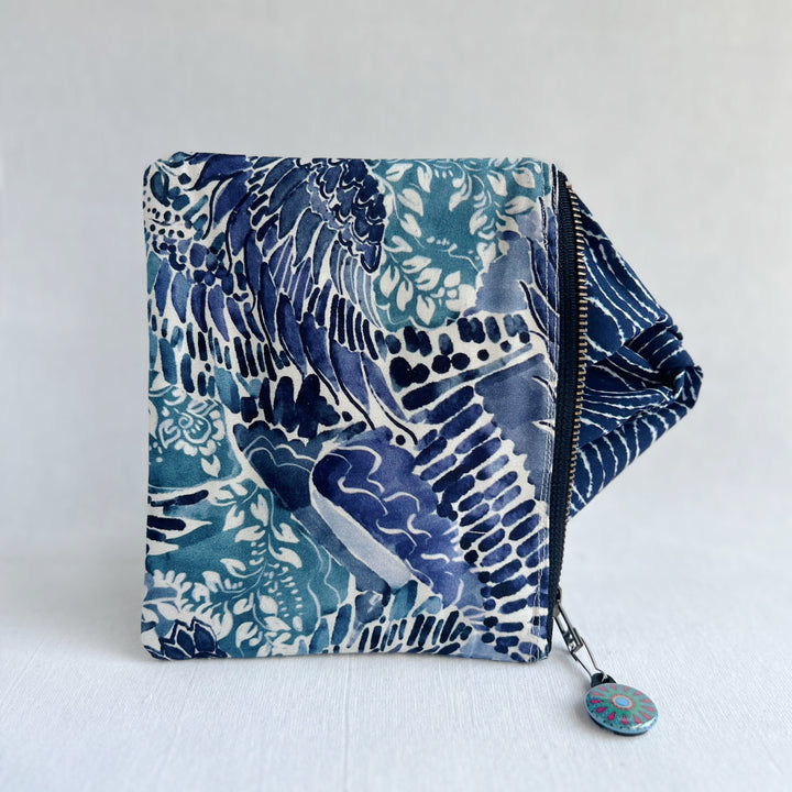 padded canvas zip bag in a colorful fabric, with a colorful zipper pull and lining