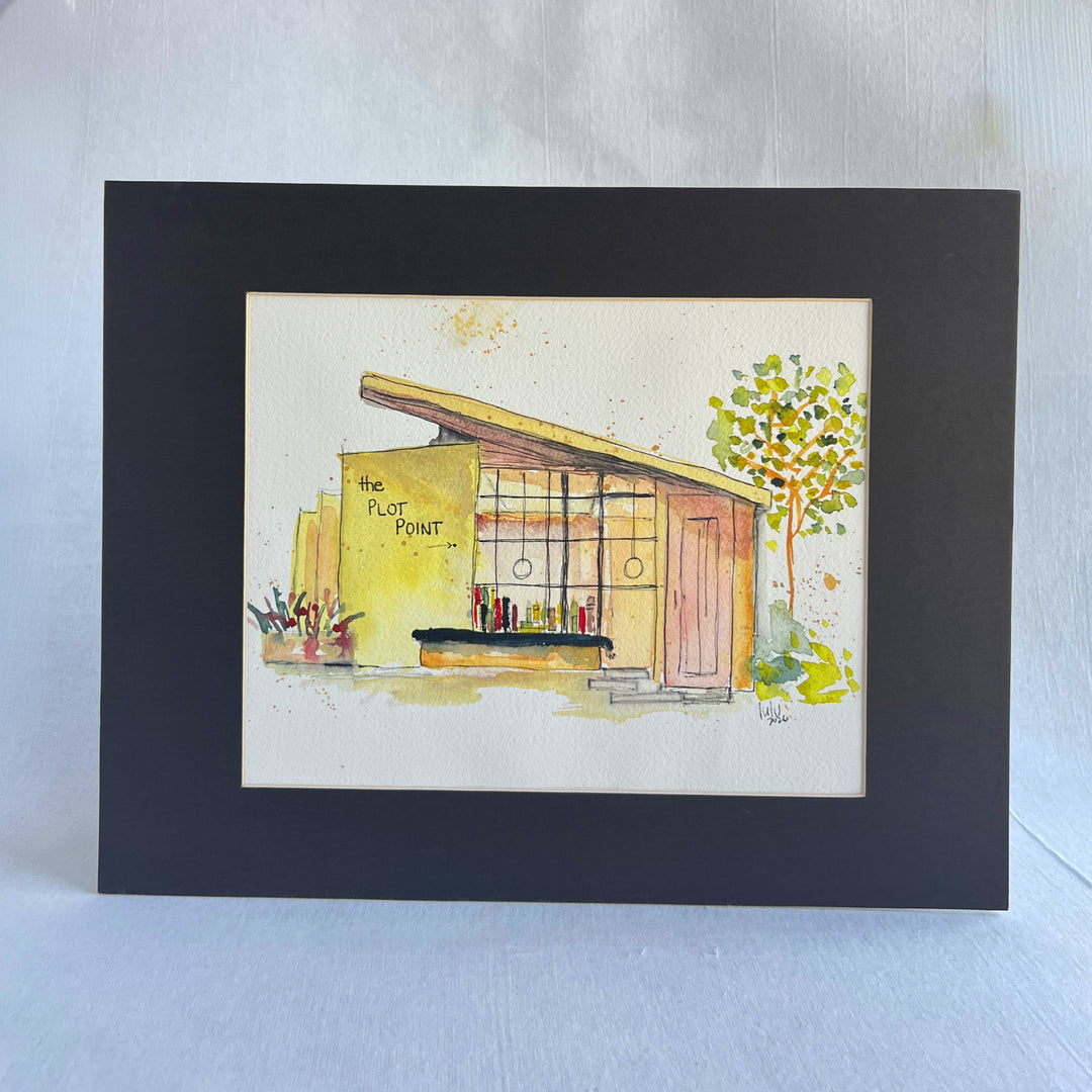 A watercolor painting of a midcentury modern bookstore with the text 'the PLOT POINT' on the yellow wall, shown on a white paper sheet against a dark navy background.