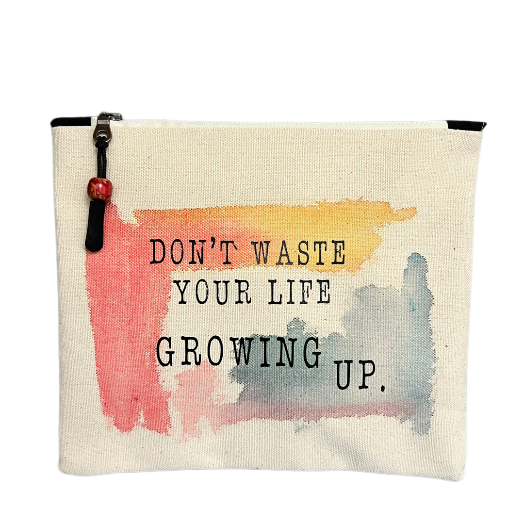 square canvas bag with paint swashes of pink, yellow and mayan blue, with the words, don't waste your life growing up.