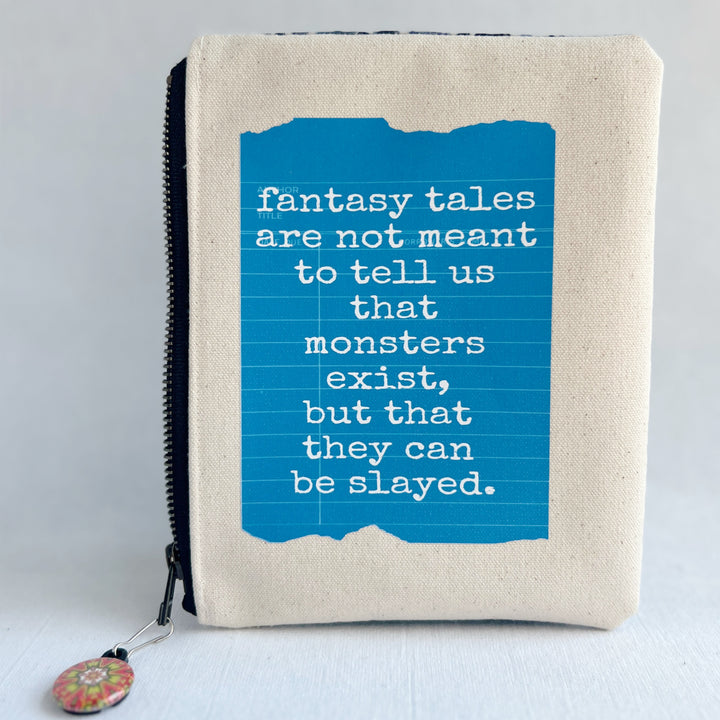 padded canvas zip bag with a blue  library card and the words, Fantasy Tales are not meant to tell us that monsters exist, but that they can be slayed, plus a colorful zipper pull and lining