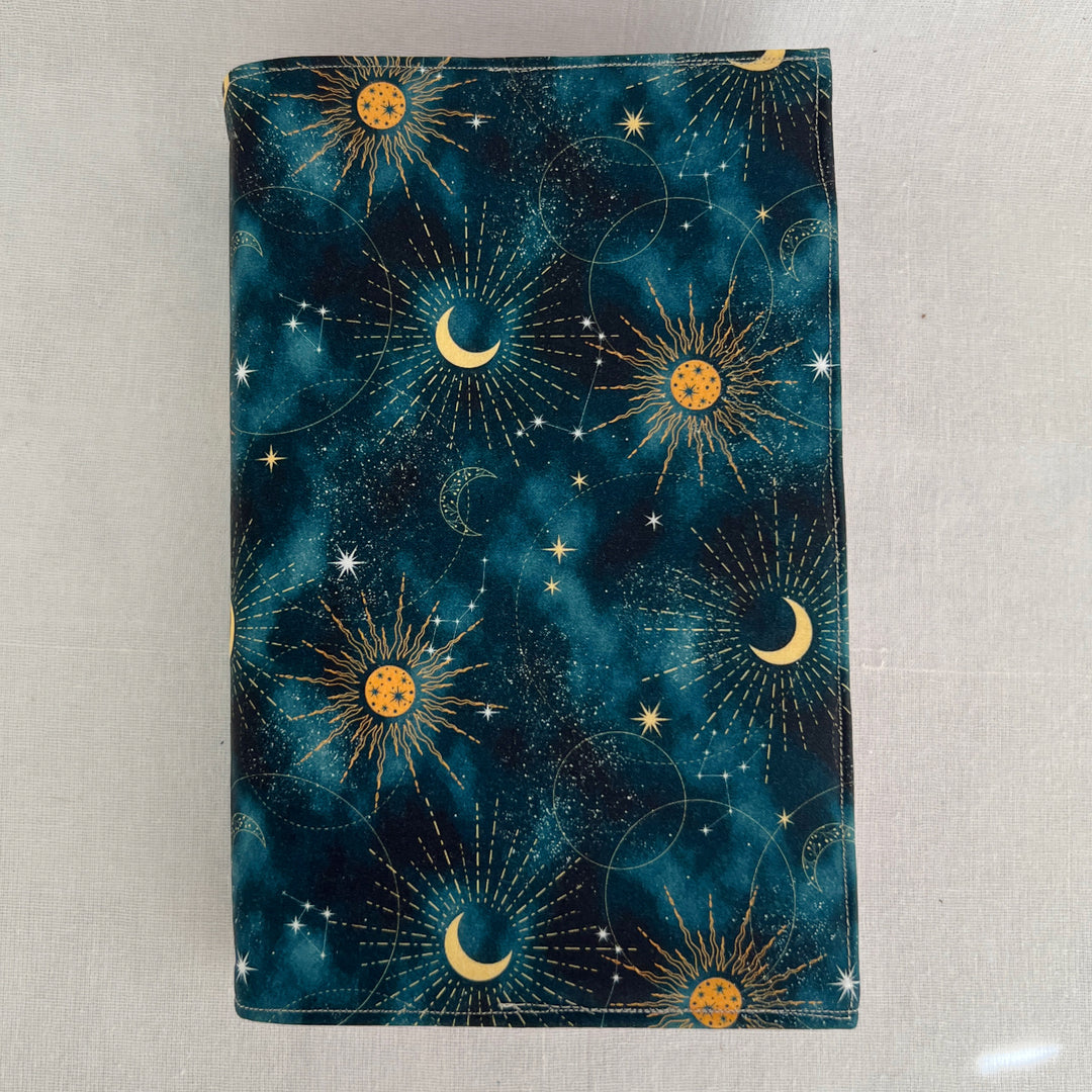 rectangular fabric batik book cover, with a celestial pattern of deep blue covered with scattered suns and moons