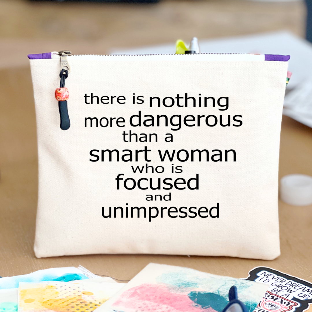 a square canvas zipper bag with the words, there is nothing more dangerous than a smart woman who is focused and unimpressed