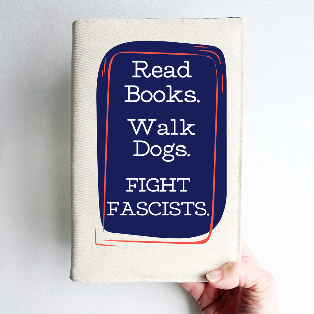 A canvas, reusable book cover in linen, with the words, 'Read Books. Walk Dogs. FIGHT FASCISTS.'  in white lettering placed on a rectangular navy box design.
