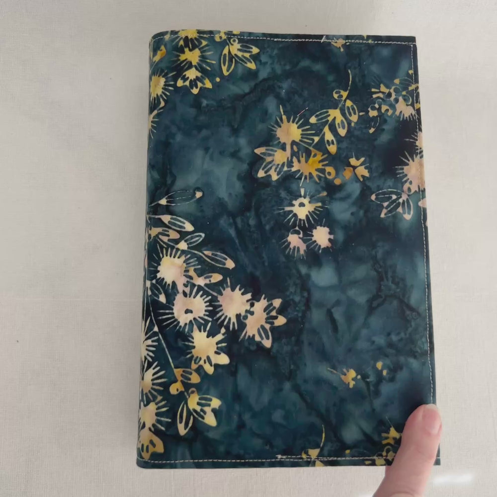rectangular book cover made of lush batik fabric in deep blues, with yellow starflower bursts of color