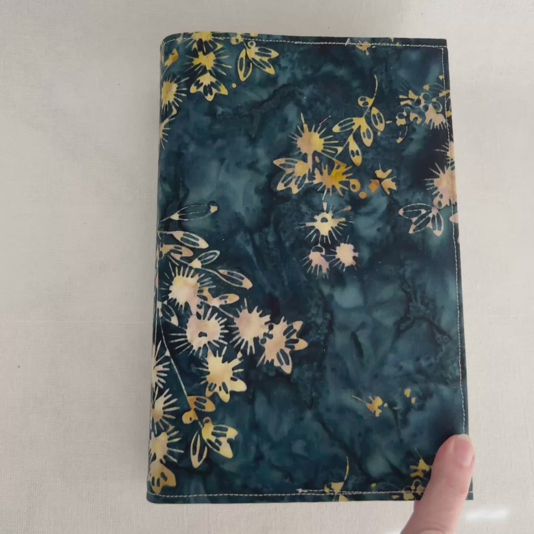 rectangular book cover made of lush batik fabric in deep blues, with yellow starflower bursts of color