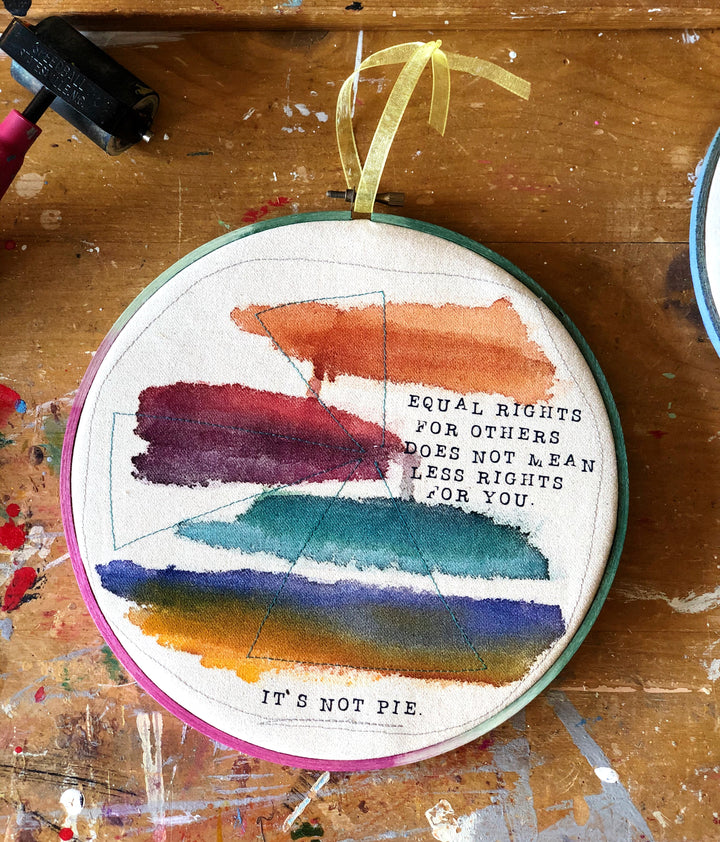 a round multicolored wooden hoop with the words, "equal rights for others does not mean less rights for you.. it's not pie."