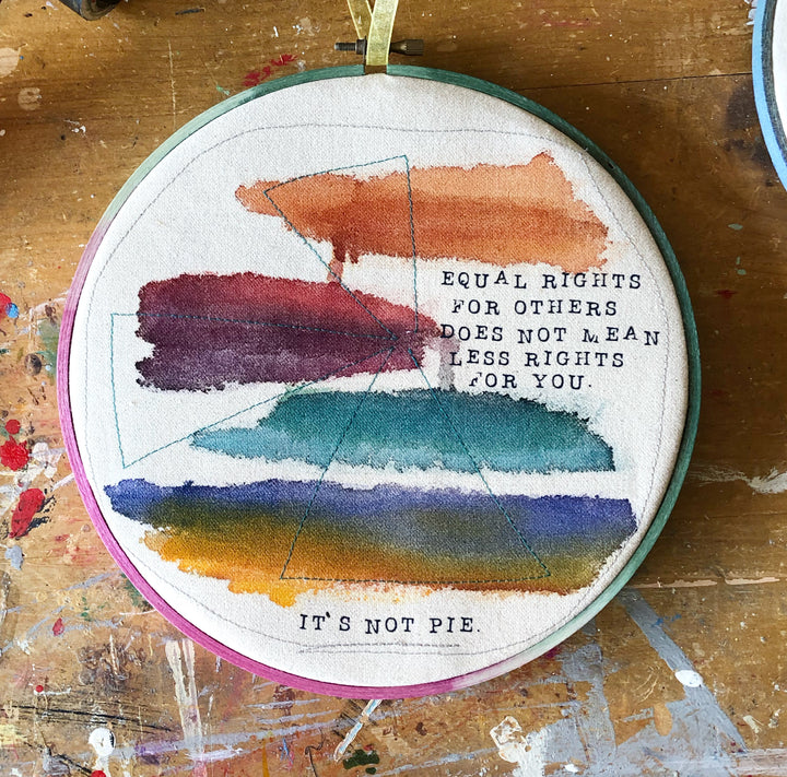 a round multicolored wooden hoop with the words, "equal rights for others does not mean less rights for you.. it's not pie."