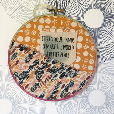 painted wooden hoop with fabric stretched and folded to make a pocket