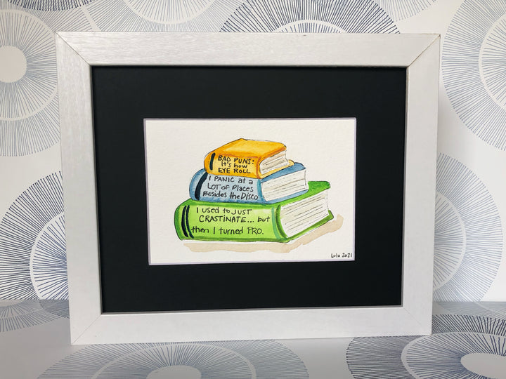 an original painted watercolor piece with three books in colors of burnt yellow, celery green and faded cerulean blue