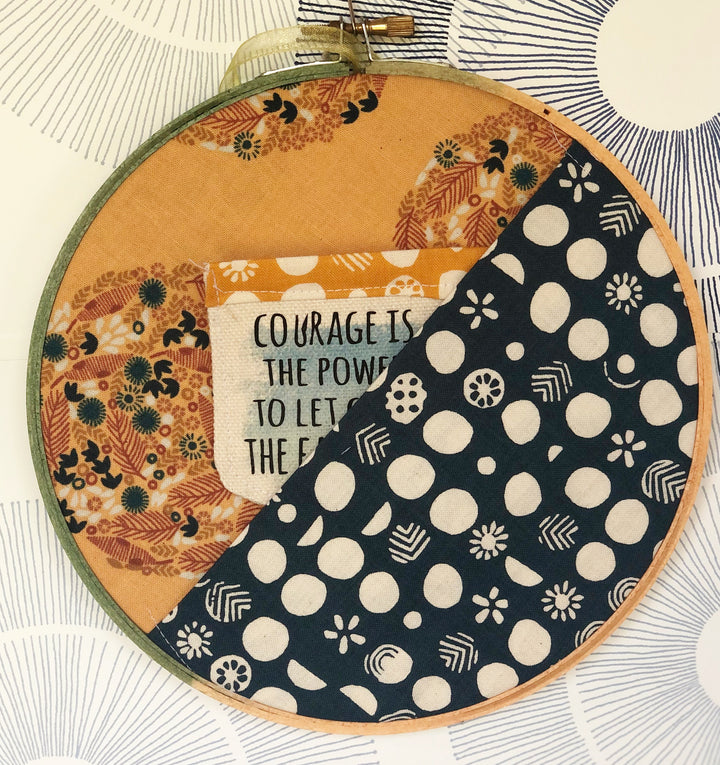 painted wooden hoop with fabric stretched and folded, creating a pocket.