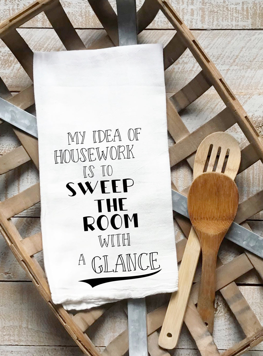 a white cotton kitchen towel with the words, "My idea of housework is to sweep the room with a glance."