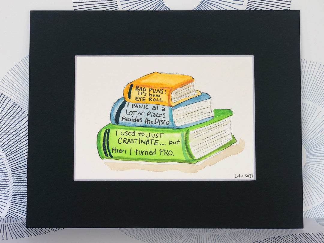 an original painted watercolor piece with three books in colors of burnt yellow, celery green and faded cerulean blue
