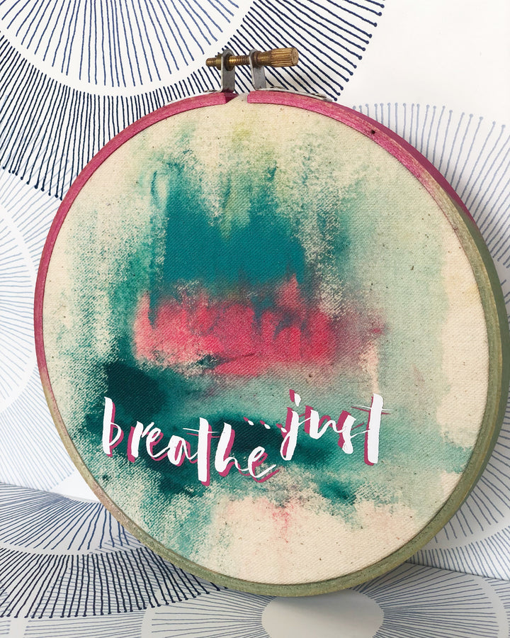 painted wooden hoop with fabric painting and the words, 'just breathe'