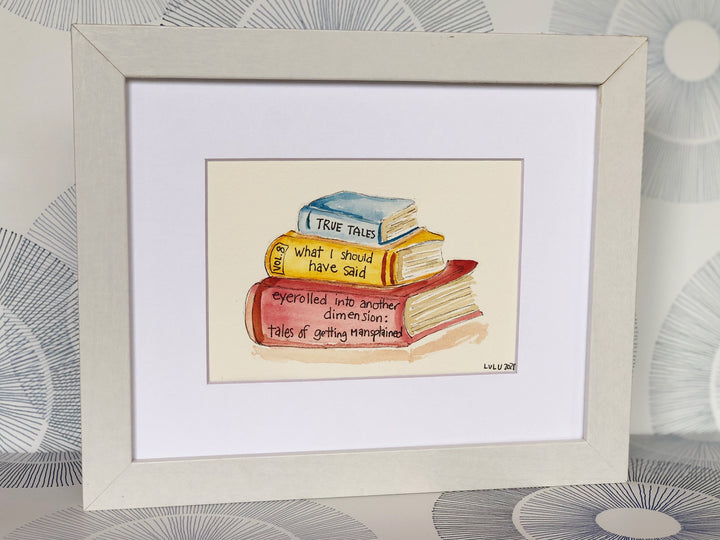 an original painted watercolor piece with three books in colors of burnt yellow, brick red and faded cerulean blue