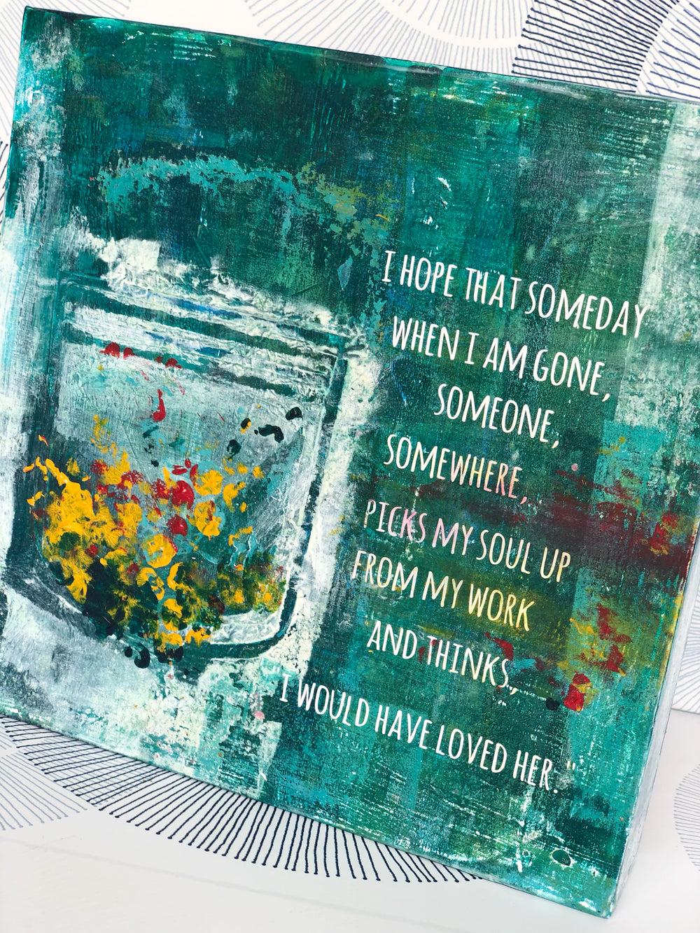 a painted wooden art piece with the words, "I hope that someday when i am gone, someone, somewhere, picks my soul up from my work and thinks...i would have loved her." Paints and inks are shades of green and teal, with accents of white, yellow and red.