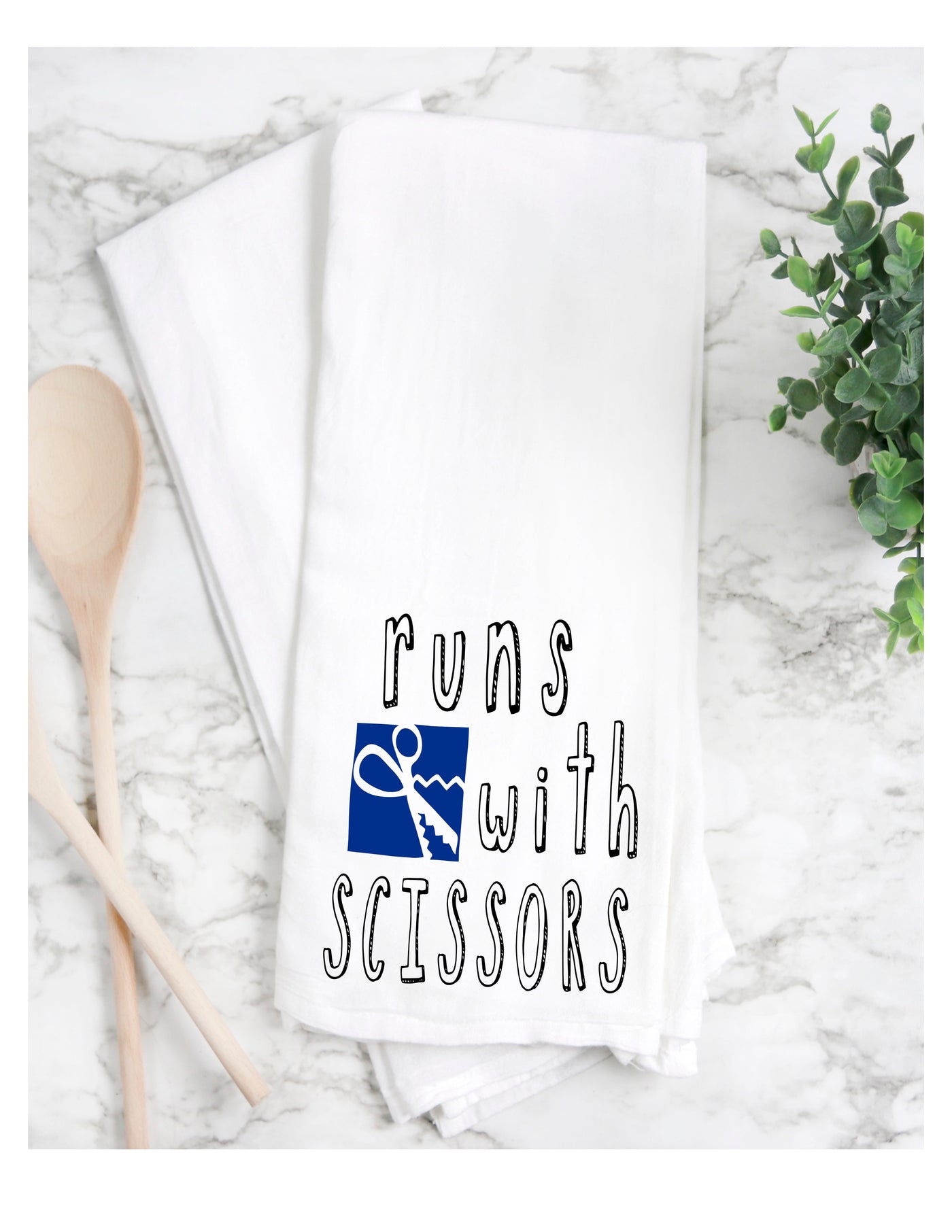 a white cotton kitchen towel with the words, "runs with scissors."
