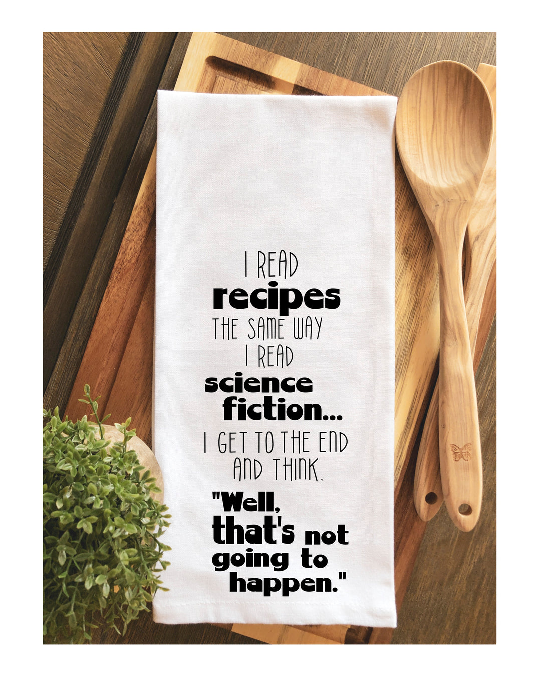 a white cotton kitchen towel with the words, "i read recipes the same way i read science fiction... i get to the end and think, "Well, ﻿that's﻿ not going to happen."