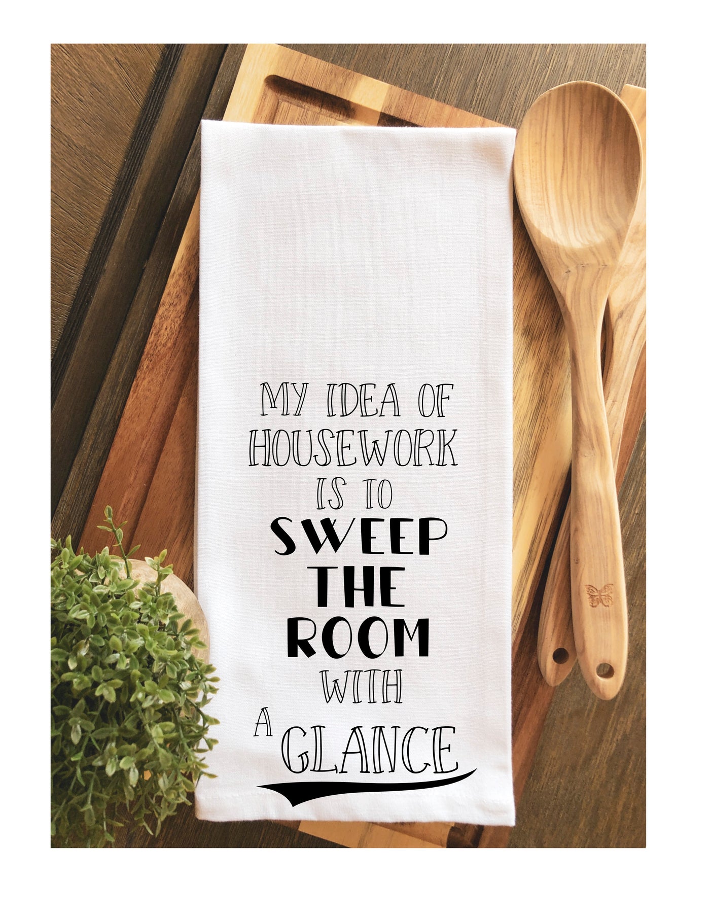 a white cotton kitchen towel with the words, "My idea of housework is to sweep the room with a glance."